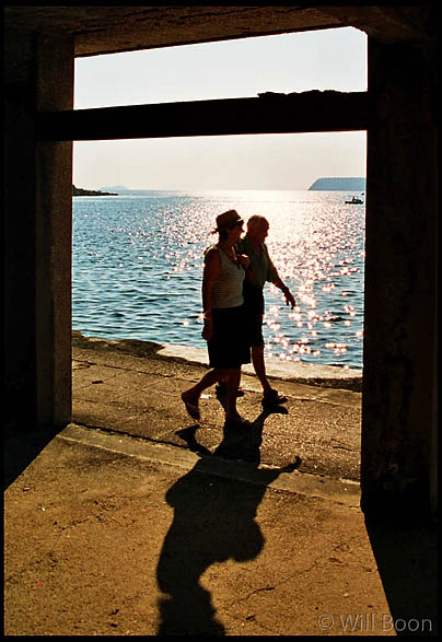 Silhouetted figures walk along the promenade, Dubrovnik