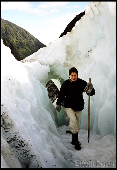 Blandine walks under a glacial arch made by Fox Glacier, South Island